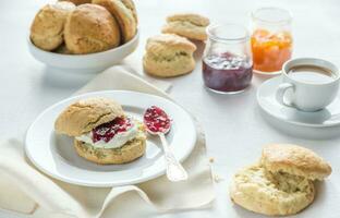 scones med grädde och frukt sylt och kopp av kaffe foto