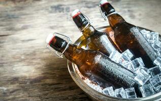 flaskor av öl i is kuber foto