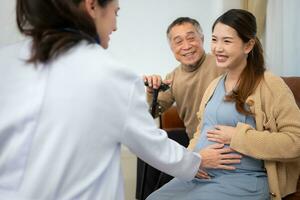 far och dotter gravid kvinna besök gynekolog läkare på medicinsk klinik för graviditet konsult. läkare undersöka gravid mage för bebis och mor sjukvård kolla upp upp. foto