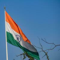 Indien flagga vajar högt på connaught plats med stolthet över blå himmel, Indien flagga vajar, indiska flaggan på självständighetsdagen och republikens dag i Indien, tilt up shot, viftande indiska flaggan, har ghar tiranga foto