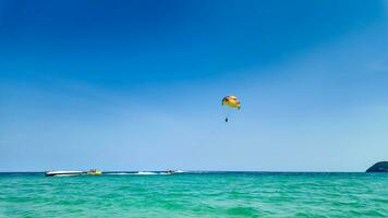 solbelyst parasailing äventyr över azurblå hav foto