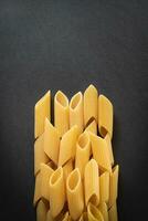 små grupp av färsk penne rigat pasta fodrad upp foto