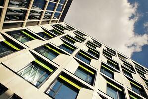 abstrakt närbild av de glasklädd Fasad av en modern byggnad täckt i reflekterande tallrik glas. arkitektur abstrakt bakgrund. glas vägg och Fasad detalj. foto