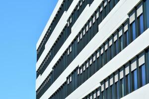 abstrakt närbild av de glasklädd Fasad av en modern byggnad täckt i reflekterande tallrik glas. arkitektur abstrakt bakgrund. glas vägg och Fasad detalj. foto