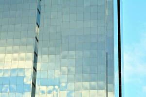 glas byggnad med transparent Fasad av de byggnad och blå himmel. strukturell glas vägg reflekterande blå himmel. abstrakt modern arkitektur fragment. samtida arkitektonisk bakgrund. foto