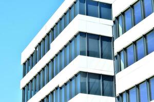 abstrakt närbild av de glasklädd Fasad av en modern byggnad täckt i reflekterande tallrik glas. arkitektur abstrakt bakgrund. glas vägg och Fasad detalj. foto