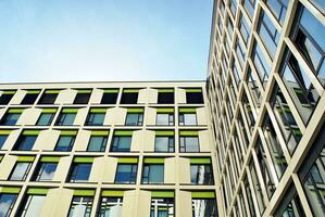 abstrakt närbild av de glasklädd Fasad av en modern byggnad täckt i reflekterande tallrik glas. arkitektur abstrakt bakgrund. glas vägg och Fasad detalj. foto