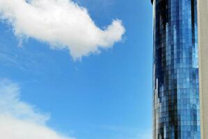 glas byggnad med transparent Fasad av de byggnad och blå himmel. strukturell glas vägg reflekterande blå himmel. abstrakt modern arkitektur fragment. samtida arkitektonisk bakgrund. foto