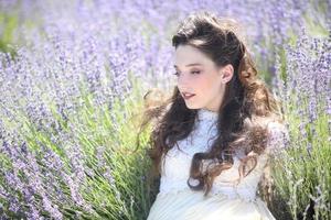 vacker ung flicka utomhus i ett lavendelblommefält foto