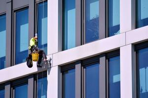 abstrakt närbild av de glasklädd Fasad av en modern byggnad täckt i reflekterande tallrik glas. arkitektur abstrakt bakgrund. glas vägg och Fasad detalj. foto