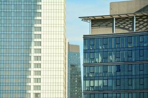 abstrakt närbild av de glasklädd Fasad av en modern byggnad täckt i reflekterande tallrik glas. arkitektur abstrakt bakgrund. glas vägg och Fasad detalj. foto