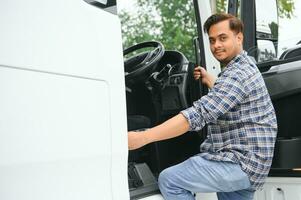 professionell indisk lastbil förare som förs in i hans lastbil lång fordon. kärleksfull hans jobb. transport tjänster foto