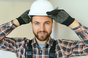 porträtt av en självsäker reparatör med skägg stående i tömma lägenhet foto