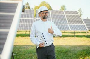 senior manlig ingenjör inspekterar sol- paneler på odla. rena energi. foto