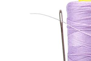 makro härva av tråd lila färger med en nål på en vit bakgrund foto