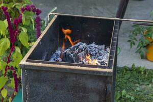 stänga upp skott av de grill med brinnande kol och trä- bitar. utomhus- foto