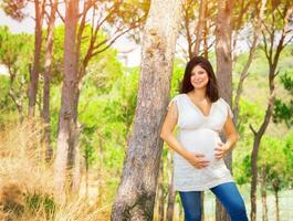 gravid kvinna i sommar parkera foto