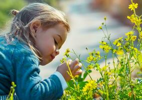 liten pojke njuter blommor arom foto