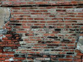 gammal riden tegel vägg fragment, urban bakgrund grunge vägg textur gammal skadad tegel vägg med plåster. yta textur av grov orange tegel vägg med tvättades ut färger. foto