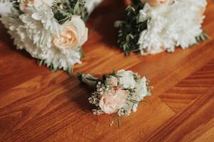 buketter av brudtärnor och brudgummens boutonniere på en brun bakgrund. en skön Foto med detaljer av de bröllop. bröllop dag. kontur ljus. skuggor och ljus