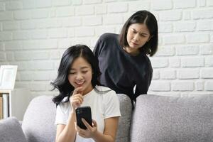 otrohet, misstänkt asiatisk lgbtq par, kvinna använder sig av cell telefon och par tittar på spionera på henne flickvän medan kvinna chattar text meddelande foto
