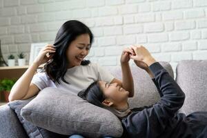 Lycklig lesbisk, attraktiv asiatisk lgbtq kvinna flirta på de soffa på Hem foto