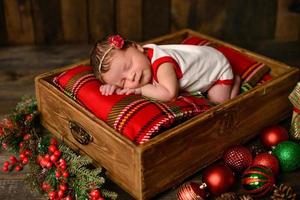 liten nyfödd tjej åtta dagar gammal i juldräkt foto