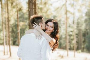 ung Lycklig par i kärlek kramas leende och har roligt i de berg. hög kvalitet Foto. en flicka i en skön vit klänning foto