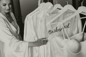 morgon- klänning av de brud och tärnor. morgon- förberedelse av de brud. de brud i en vit bröllop klänning med spets stående i de rum. selektiv fokus foto