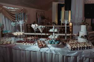 en utsökt bröllop. godis bar för en bankett. firande begrepp. modern desserter. tabell med sötsaker, godis. frukt foto
