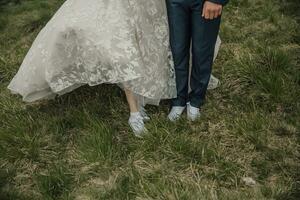 Lycklig bröllop par i de berg. skor på en bröllop. lätt stil. bröllop klänning och sneakers. bröllop Foto session i natur. Foto session i de skog av de brud och brudgum.