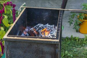 stänga upp skott av de grill med brinnande kol och trä- bitar. utomhus- foto