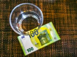 stor euro räkningen pengar på tabell och glas av vatten. foto