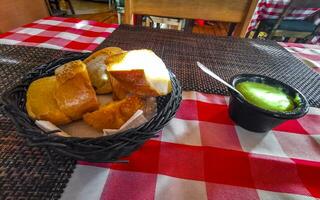 bröd i korg och grön koriander sås restaurang Mexiko. foto