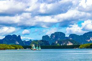 tropisk paradis turkos vatten strand kalksten stenar fiskebåtar krabi thailand. foto