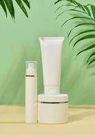 vit plast rör, burkar på en grön bakgrund, behållare för kosmetisk krämer och geler, foto
