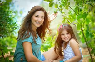 mor med dotter i de fruktträdgård foto