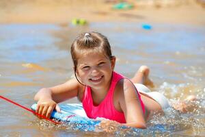 glad liten flicka på stranden foto