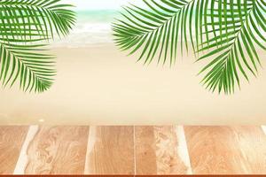 trä bordsskiva på suddig strandbakgrund med grönt palmblad, sommarkoncept foto