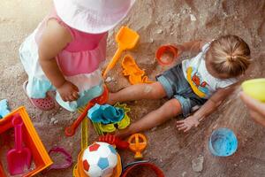 Lycklig barn spela i sandlåda foto