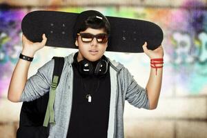 eleganta tonåring pojke med skateboard foto