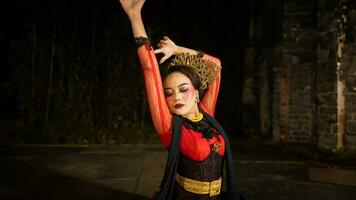 ett indonesiska dansare söker ut och inviterar de publik till vara genom bort i en kulturell prestanda foto