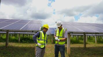 professionell asiatisk man ingenjör använder sig av digital läsplatta upprätthålla sol- cell paneler tillsammans .tekniker team arbetssätt på ekologisk sol- odla. foto