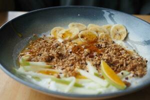 frukost granola skål med banan och honung foto