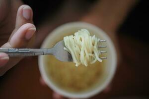 topp se av äter omedelbar kopp spaghetti foto