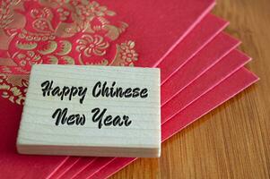 Lycklig kinesisk ny år lyckönskningar med röd paket kuvert foto