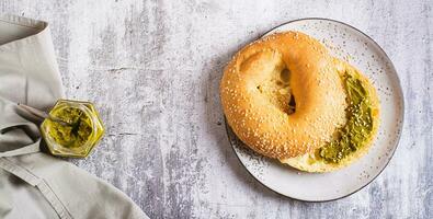 bagel med pistasch grädde Smör och en burk av Smör på en tallrik på de tabell topp se webb baner foto