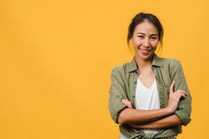 porträtt av ung asiatisk dam med positivt uttryck, korsade armar, le brett, klädd i vardagskläder och titta på kameran över gul bakgrund. glad förtjusande glad kvinna jublar över framgång. foto