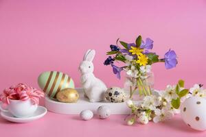 vit kanin, blommor och påsk ägg på en rosa bakgrund och påsk ägg på en rosa bakgrund foto