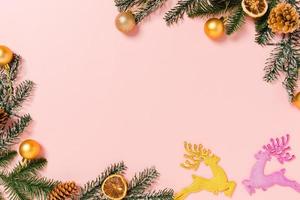 minimal kreativ lägenhet av julens traditionella komposition och nyårshelger. ovanifrån vinter juldekorationer på rosa bakgrund med tomt utrymme för text. kopiera rymdfotografering. foto